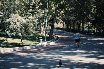 Henkilö juoksemassa vehreässä puistossa